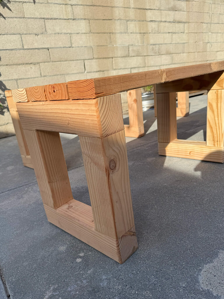 Close-up legs of a custom 2x4 bench with clean joinery and square design.